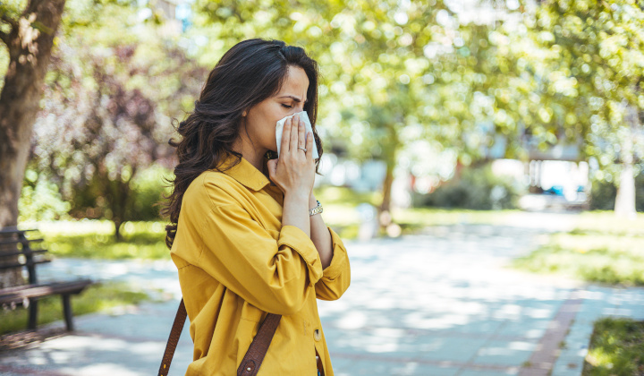 Frau mit Allergie schnäuzt sich die Nase